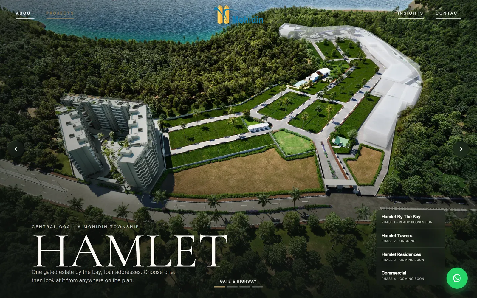 Gate-and-highway vantage: the modelled estate from the coast road, completed tower at left, plotted streets and bay beyond